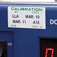 Una etiqueta de apariencia metálica colocada eb un panel de equipo