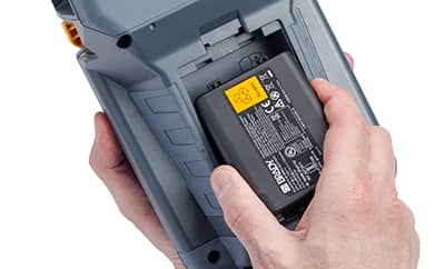 Una persona instalando una batería de alta capacidad en una impresora Brady M510