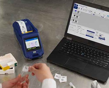 Una persona aplicando una etiqueta impresa con la M611 en un portaobjetos de laboratorio.