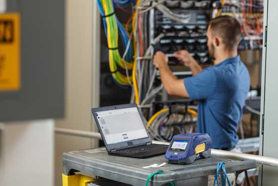 Contratista de datacomm usando una impresora de etiquetas M611 de Brady